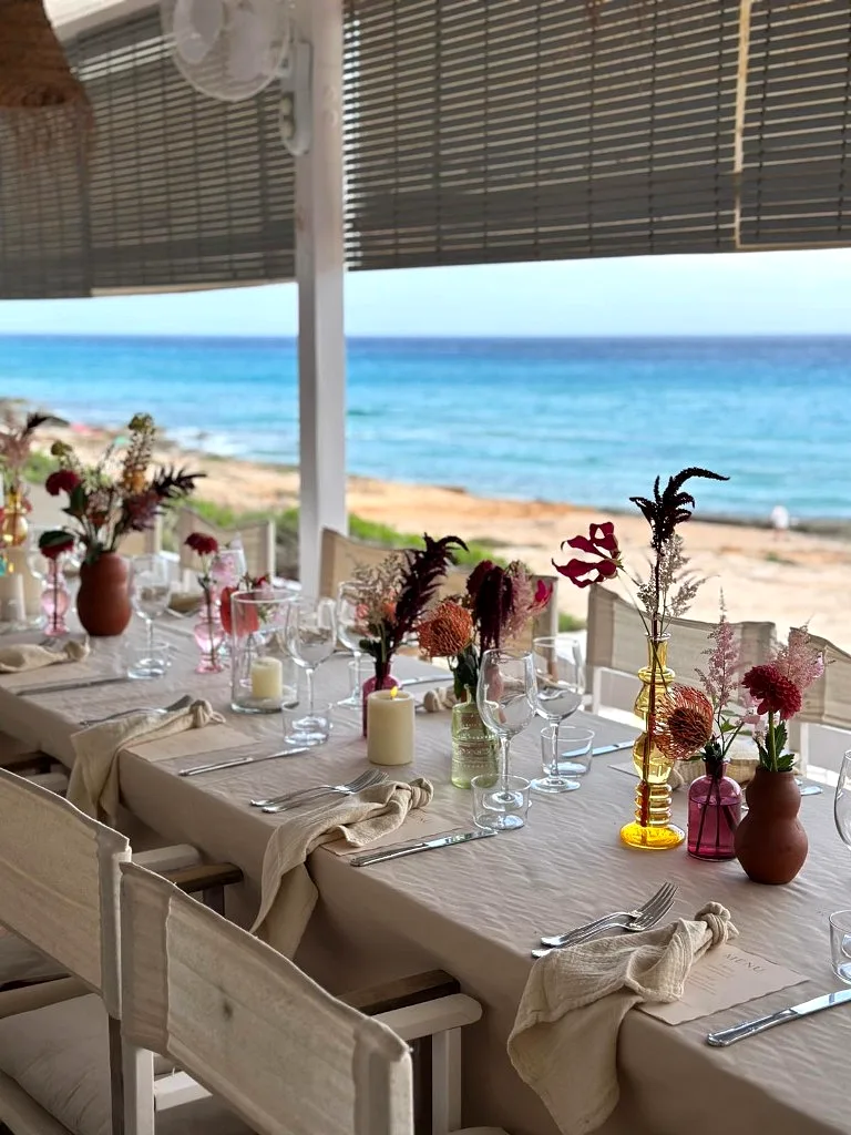 Burgundy floral centrepieces overlooking the sea